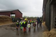 Kinder auf einem Bauernhof im Regen