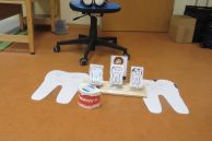 Eine Handpuppe sitzt vor verschieden großen Zähnen an denen er erklärt wie man sich die zähne puzt.